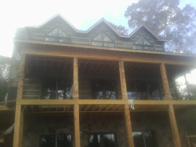 Dormers and porch framing on a large log home under construction — Roof Coating work by our crew in Bothell