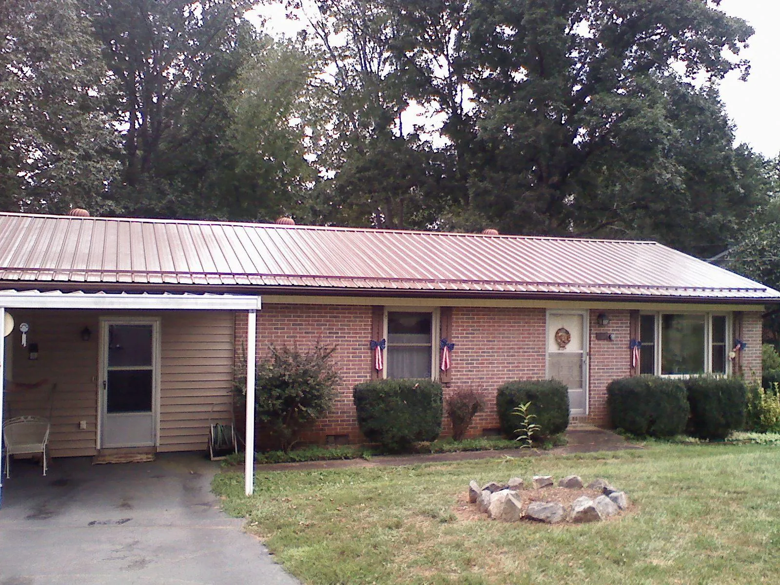 Bronze metal roof and carport on a brick ranch home — Roof Repair work by our crew in Bothell